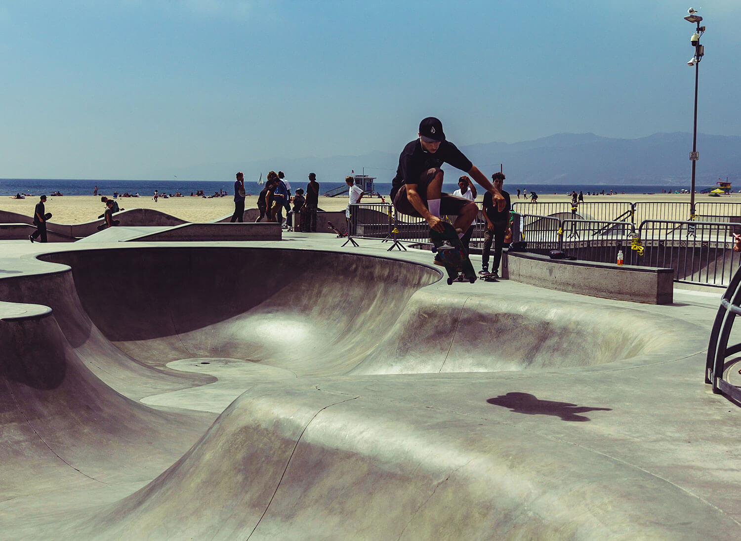 Man mid air on skateboard at Los Angeles Beach skate-bowl