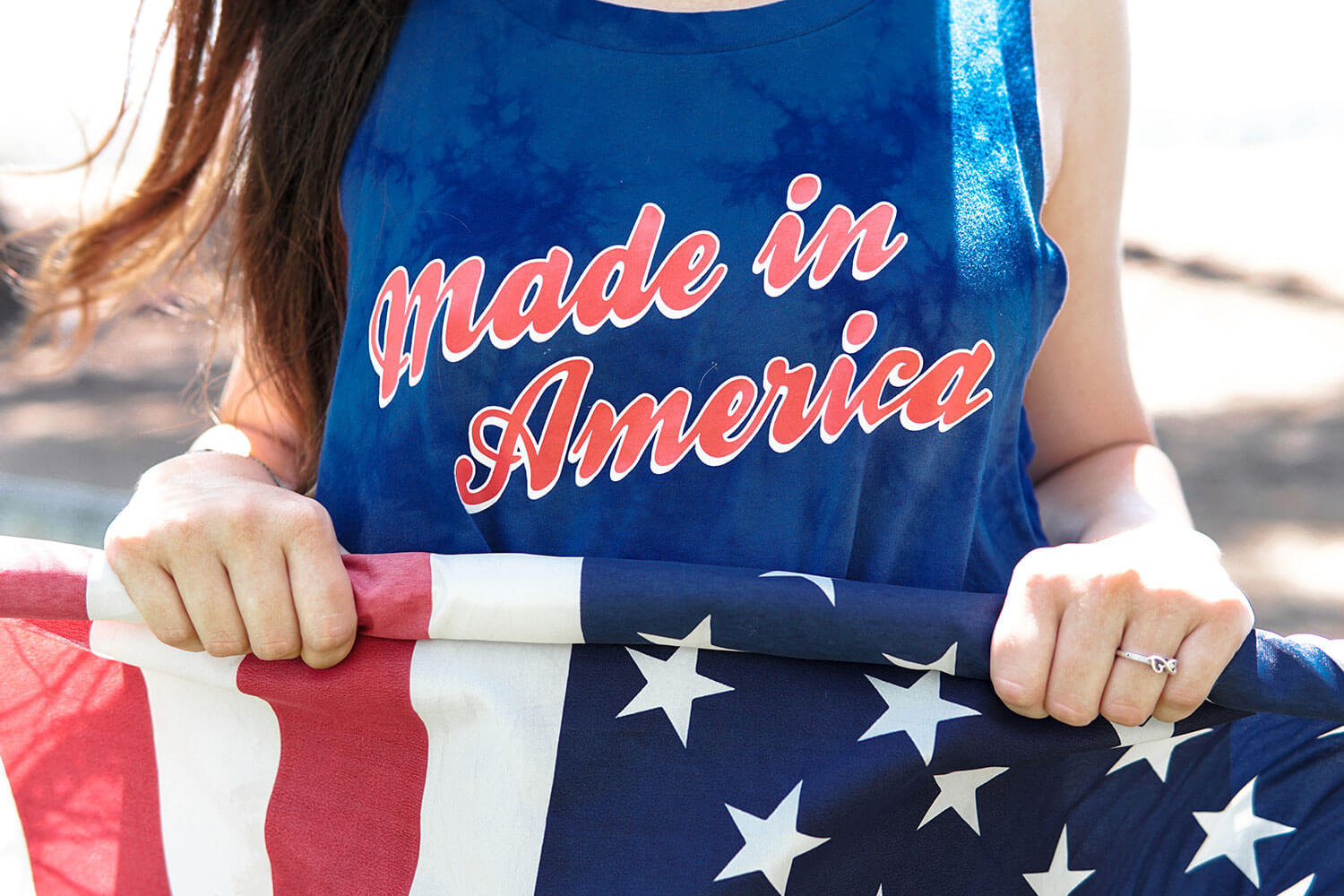Closeup shot of Woman wearing 'Made in America' singlet holding an American flag